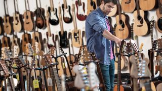 Man looking at guitars in a guitar store