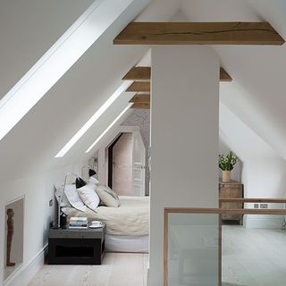 attic bedroom with white wall and cushion