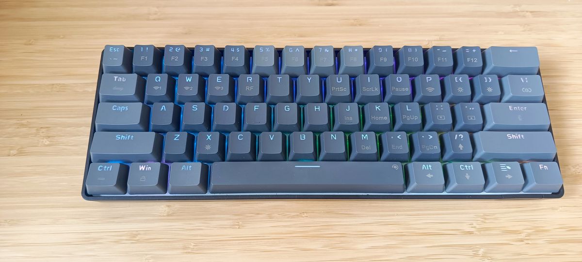 A grey Sablute SG KM61 keyboard sitting on a wooden desk