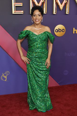 Liza Colón-Zayas wears a custom green off-the-shoulder sequin gown by Christian Cowan