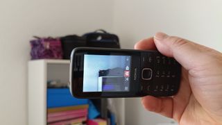 Hand holding a dumbphone 