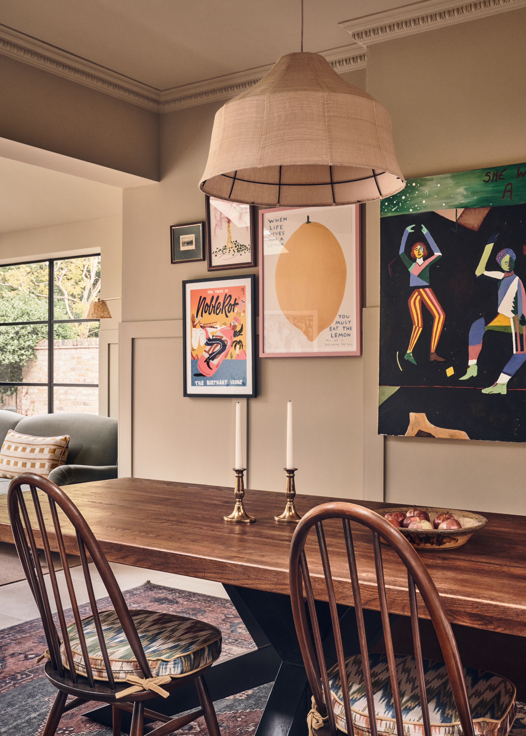 dining area with a dark wooden table and framed art on a gallery wall opposite