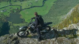 Tom Cruise looking off cliff on a motorcycle in Mission: Impossible 7 trailer