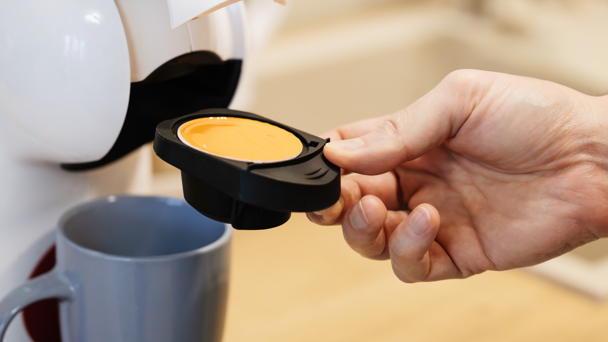 Person inserting coffee pod in espresso machine