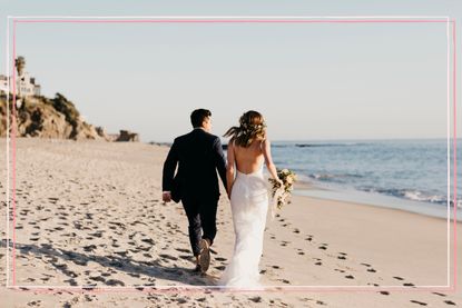 A bridal couple running along a beach