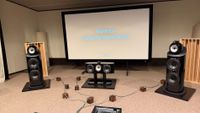 A pair Bowers & Wilkins speakers and a centre channel set up in a reference listening space