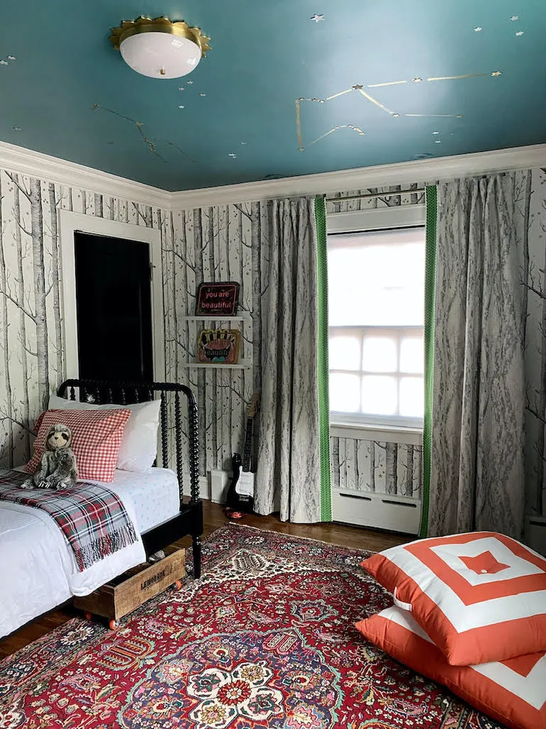 A bedroom with a dark green painted ceiling
