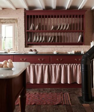 Burgundy rustic kitchen with cupboard skirting