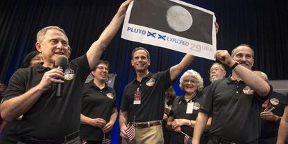 NASA crew members celebrate New Horizons confirming it survived its flyby.