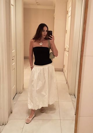 Fashion editor Anna LaPlaca in black tube top and white skirt.