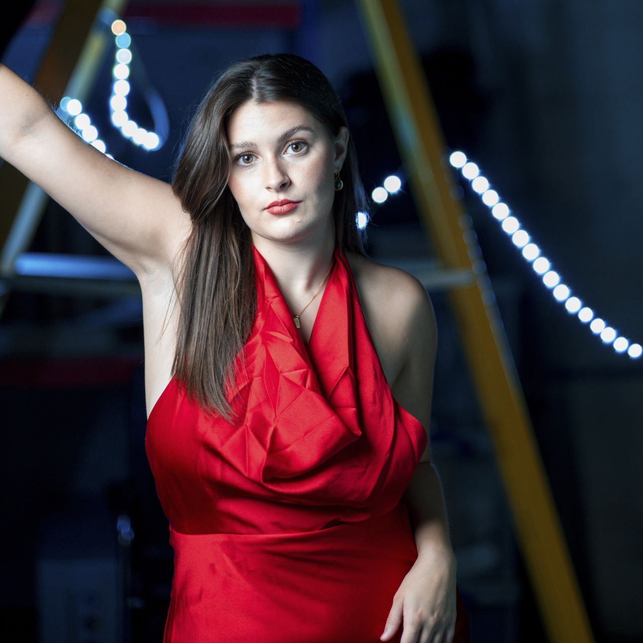Female model with dark hair in red dress, outdoors at night, taken with the Alice Camera