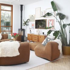 A white living room with a brown King Living 1977 modular sofa and a gallery wall