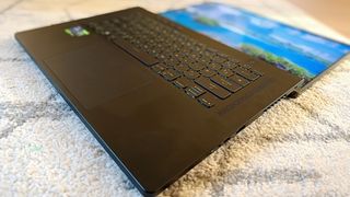 An ASUS ROG Zephyrus M16 gaming laptop, one of the best ASUS laptops sitting on a rug