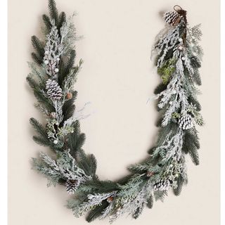Snow covered artificial garland with pine cones