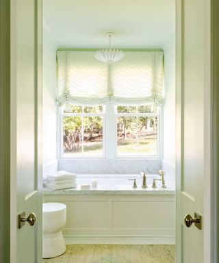 A light green bathroom with a standalone tub