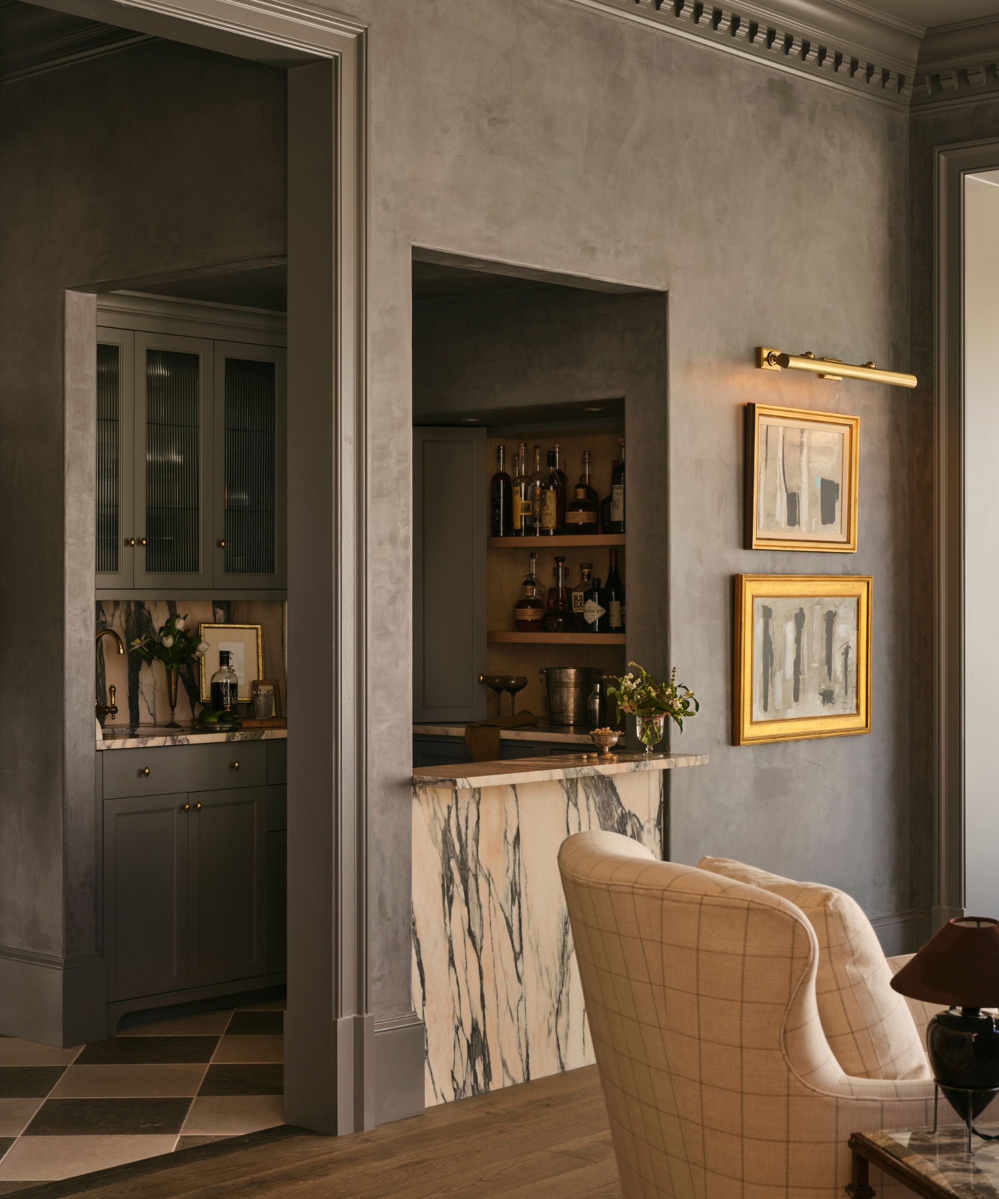 a grey blue painted home bar with marble stone and antique artwork