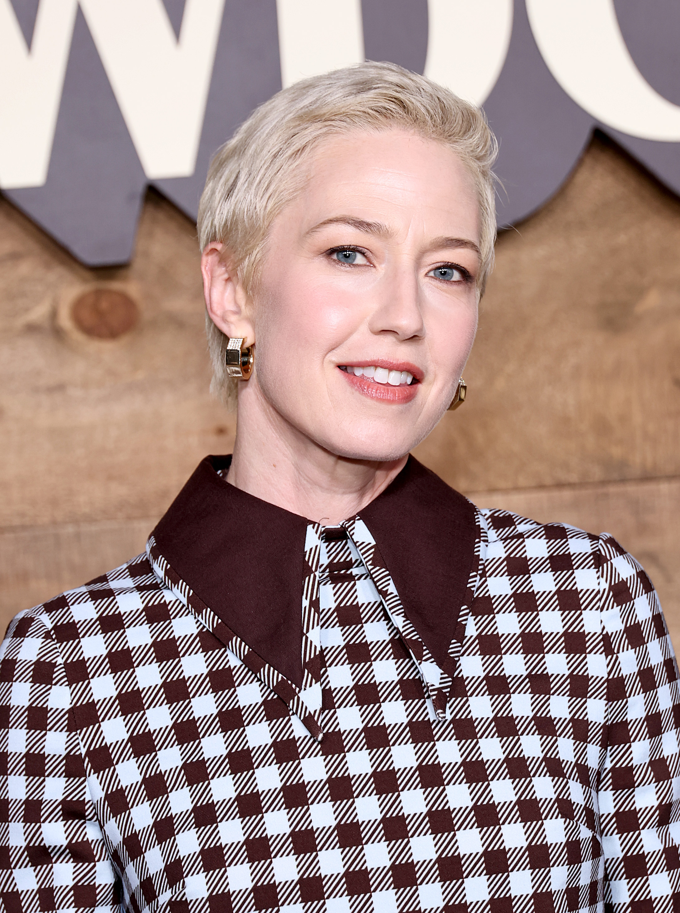 a white woman with short blonde hair posing for a photo at a red carpet event