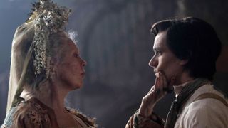 Olivia Colman in a white head-dress as Miss Havisham touches the face of Fionn Whitehead in a white shirt as Pip in Great Expectations.