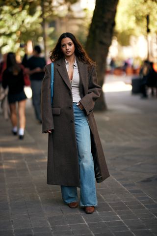 woman wearing baggy shirt and brown coat