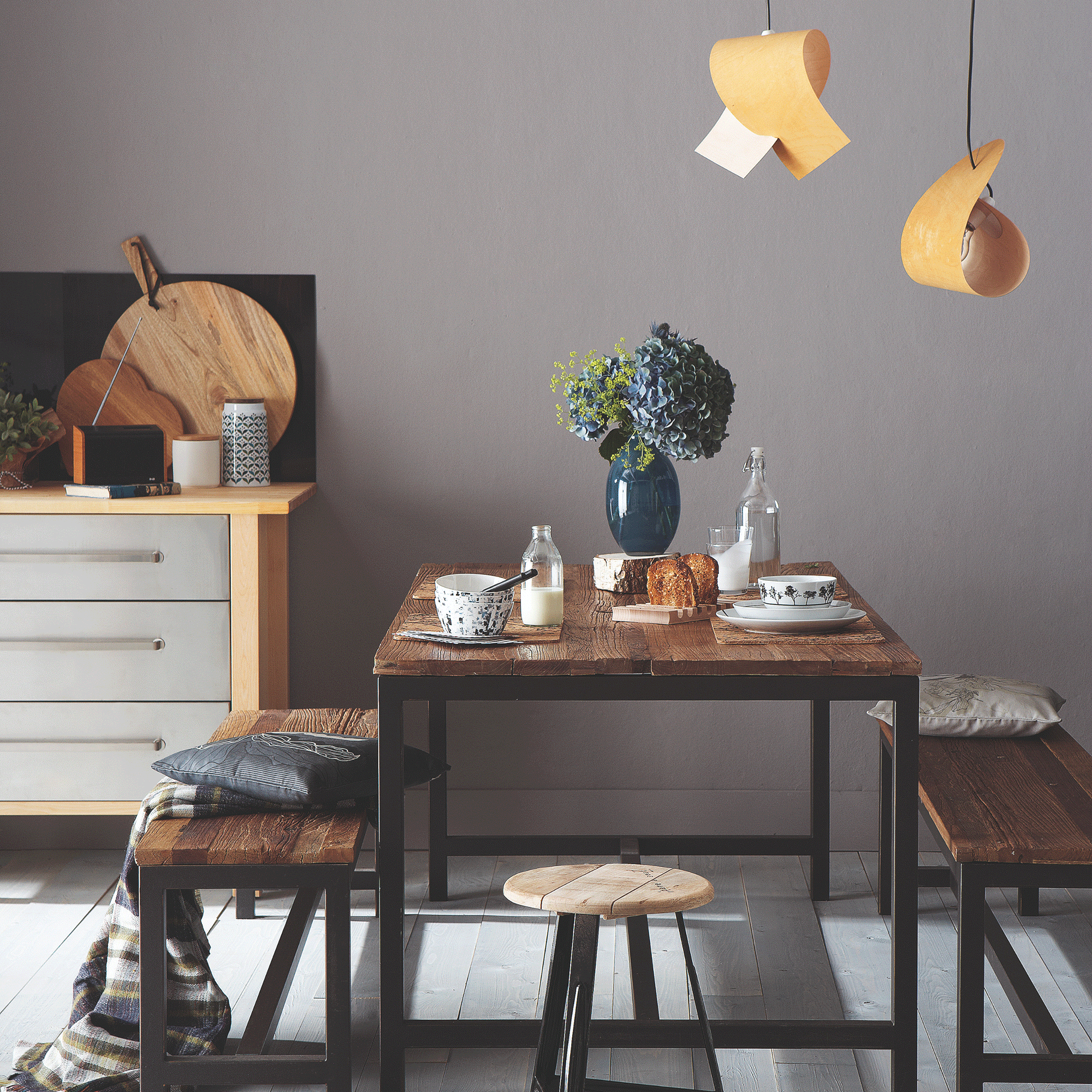 Grey dining room with wooden table and pendant lights