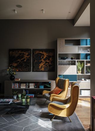 Dark grey living room with yellow armchairs