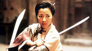 Beste asiatiske filmer: Michelle Yeoh står med to sverd i filmen Snikende Tiger, Skjult Drage