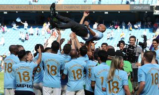Pep Guardiola is thrown in the air by his Manchester City players after winning the Premier League in 2017-18