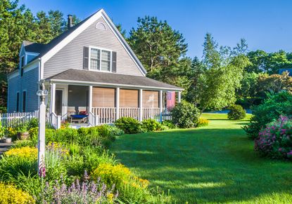 A house with a healthy front lawn and flower border