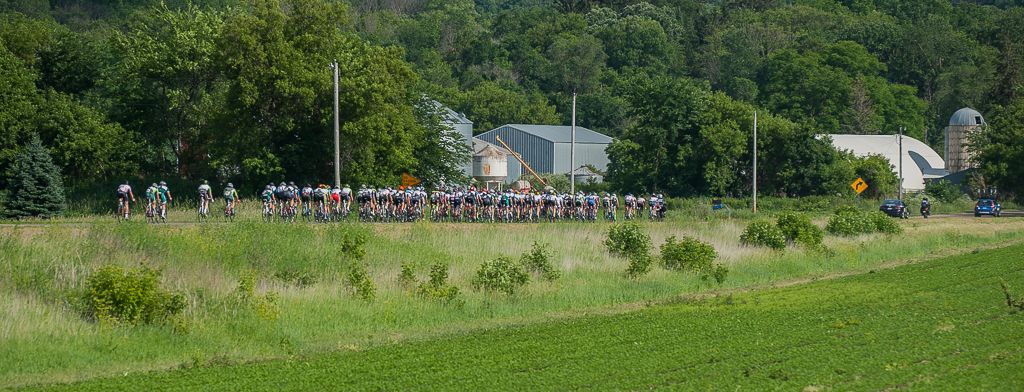 The peloton rolls through the country side among the many farm fields