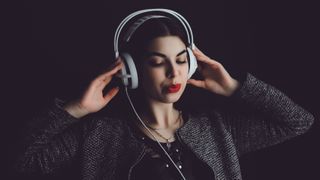 Young woman listening music in headphones