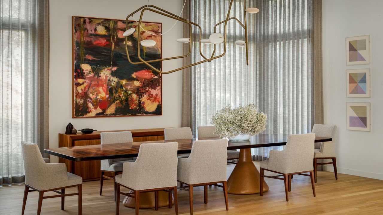 dining room with white chairs and bold artwork contemporary chandelier