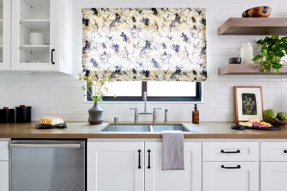 How do you make a boring kitchen look good? White kitchen with open shelving and patterned blinds by LH.Designs