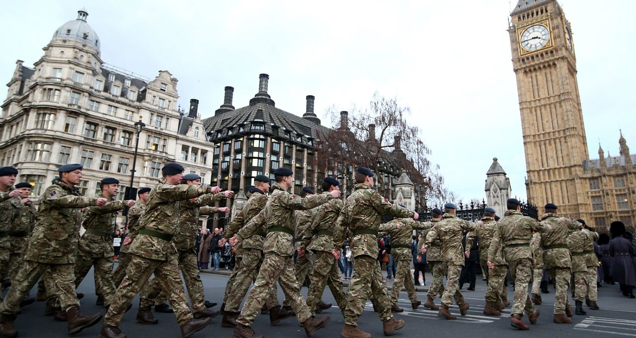 Military personnel march into the Houses of Parliament