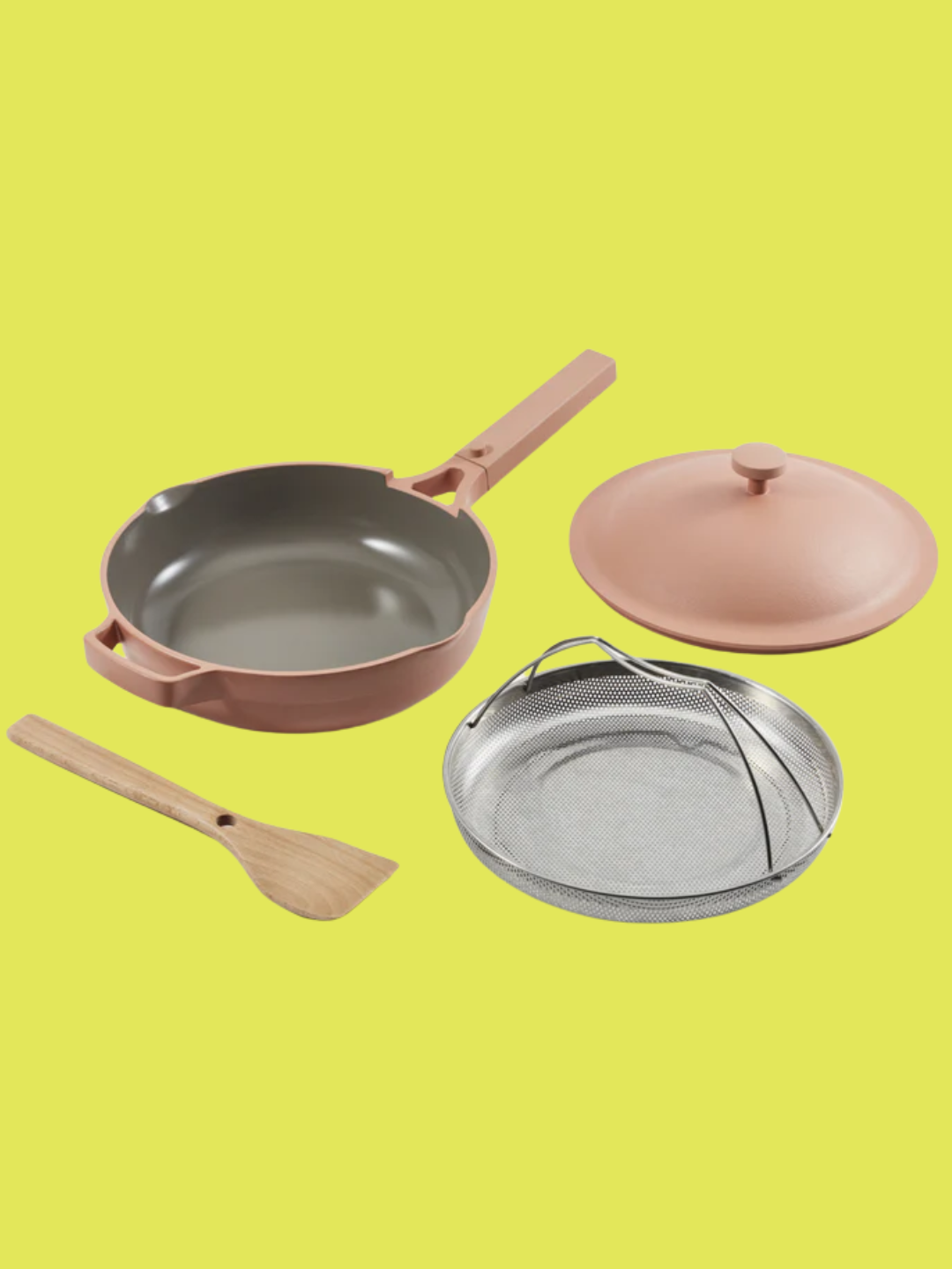 A cream orange ceramic pan, lid, wooden spoon, and steel insert from Our Place