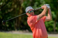 man playing golf with sunglasses on