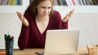 A woman getting frustrated by her laptop