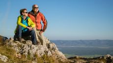 Senior couple on top of mountain enjoying the view