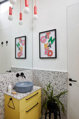 Bathroom with yellow under sink storage and terrazzo splashback