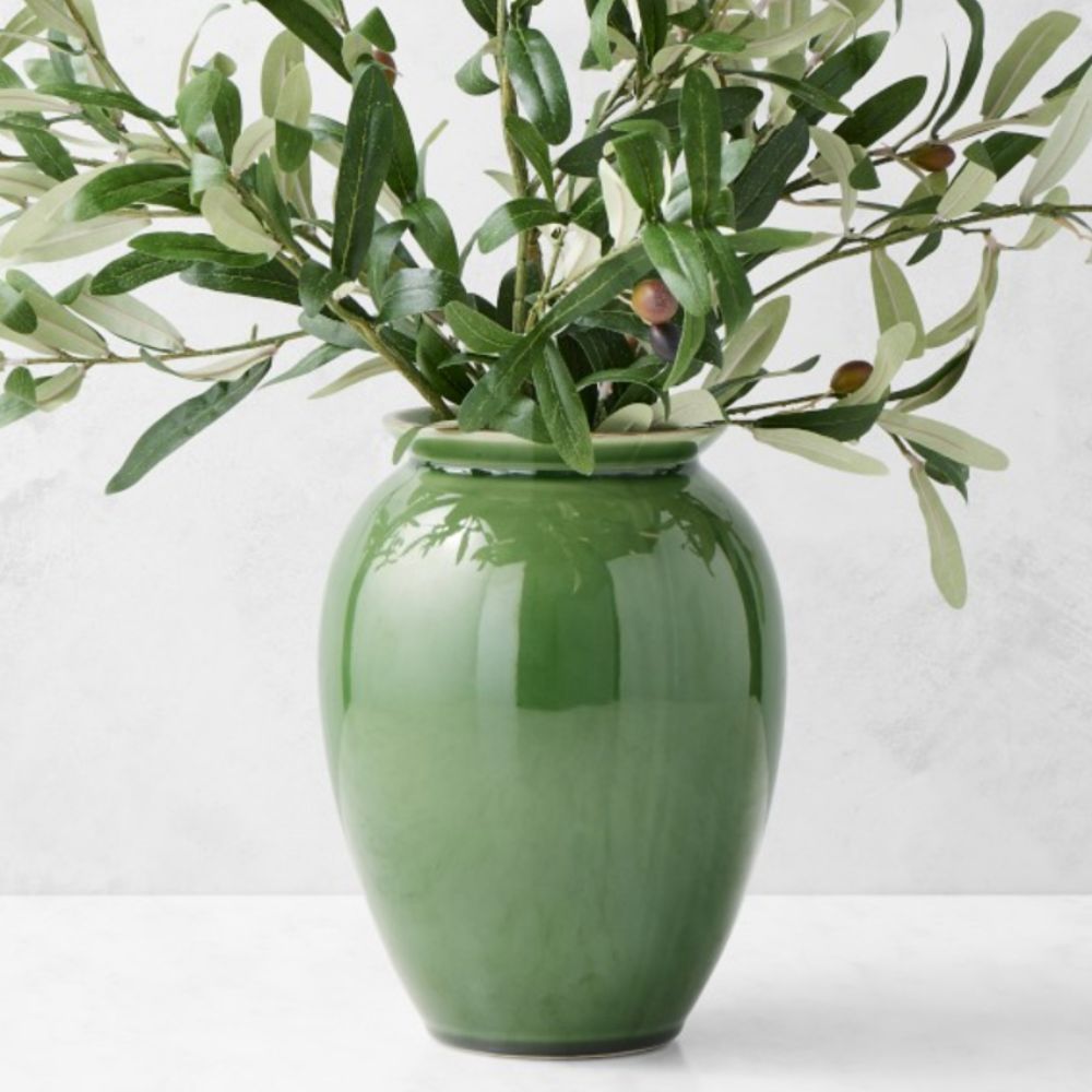 Large green glazed vase filled with olive branches