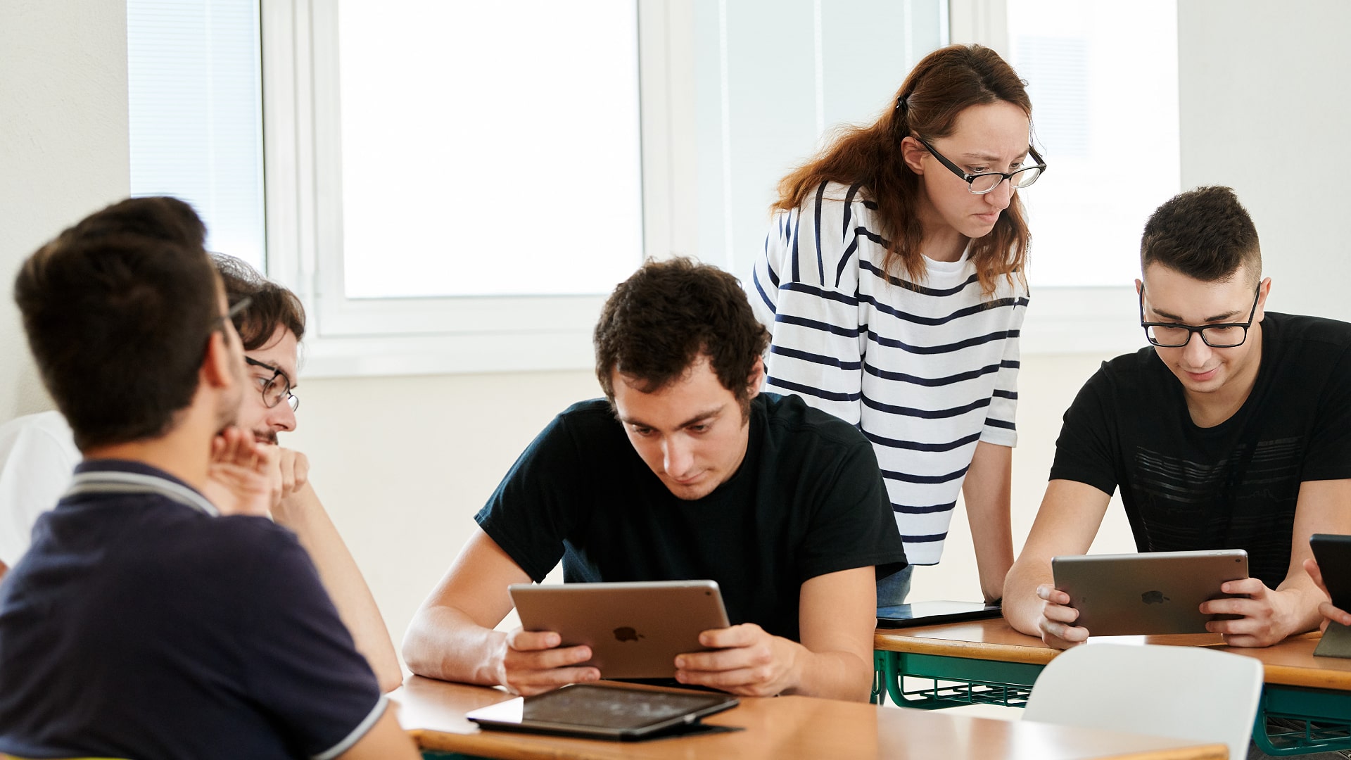 Students using Apple devices in a classroom.