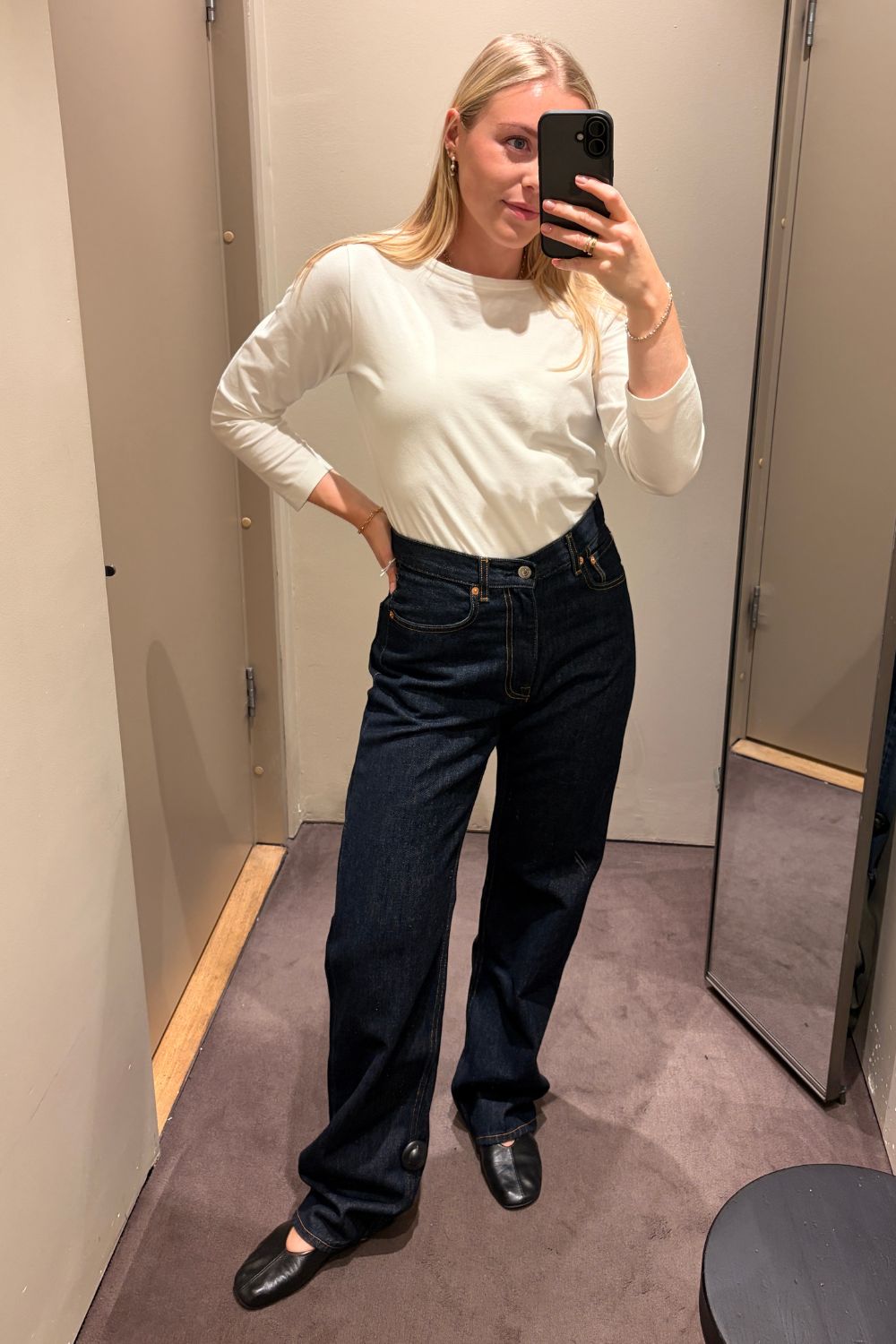 Shopping editor, Florrie, wears a white long-sleeved top, dark indigo COS Chord straight-leg jeans, black ballet flats