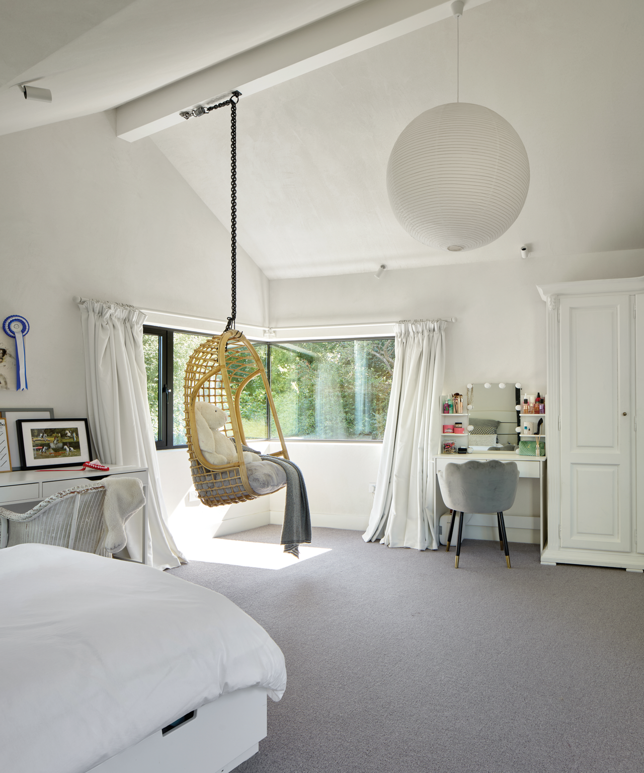 White bedroom with swinging chair in the middle