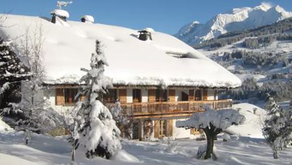 wooden house roof covered by snow and snow mountain