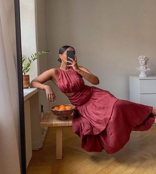 @femmeblk wearing a burgundy maxi with cut-out waist