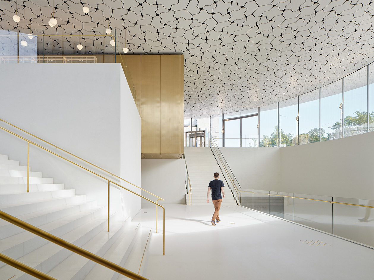 JKMM - National Museum of Finland view of round, white and gold underground building next to the historical one
