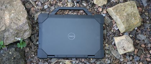 A black Dell Latitude 7330 Rugged Extreme laptop sitting on a rocky surface