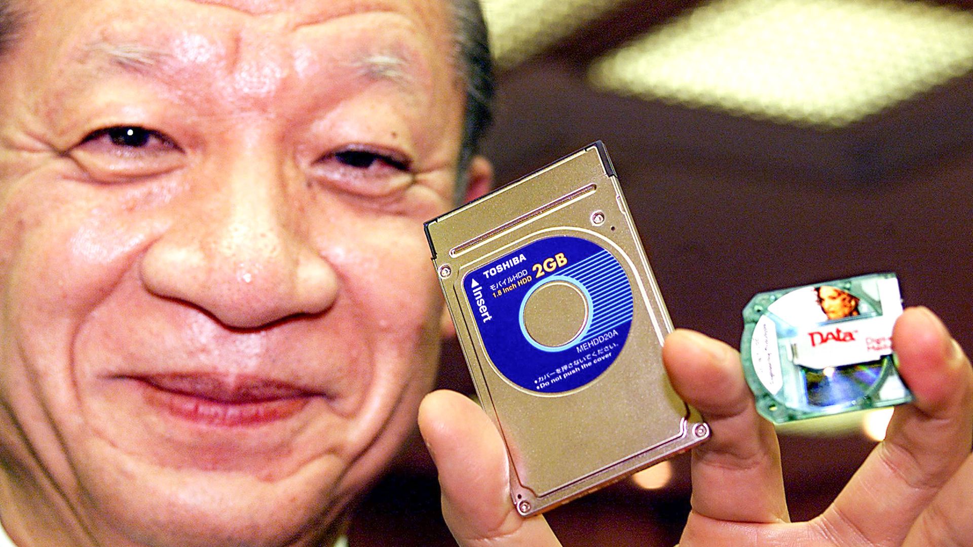Japan's electronics giant Toshiba Chairman Taizo Nishimuro displyas the company's latest product PCMCIA type II sized 2 GB HDD (C), world's highest capacity 1.8-inch HDD media, in December 2000.