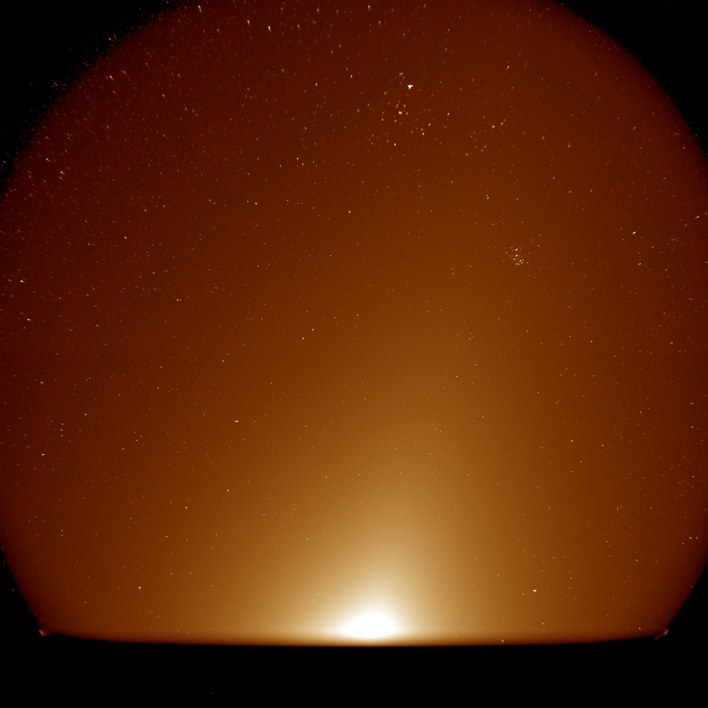 a colorful gradient of light seen against a starry background
