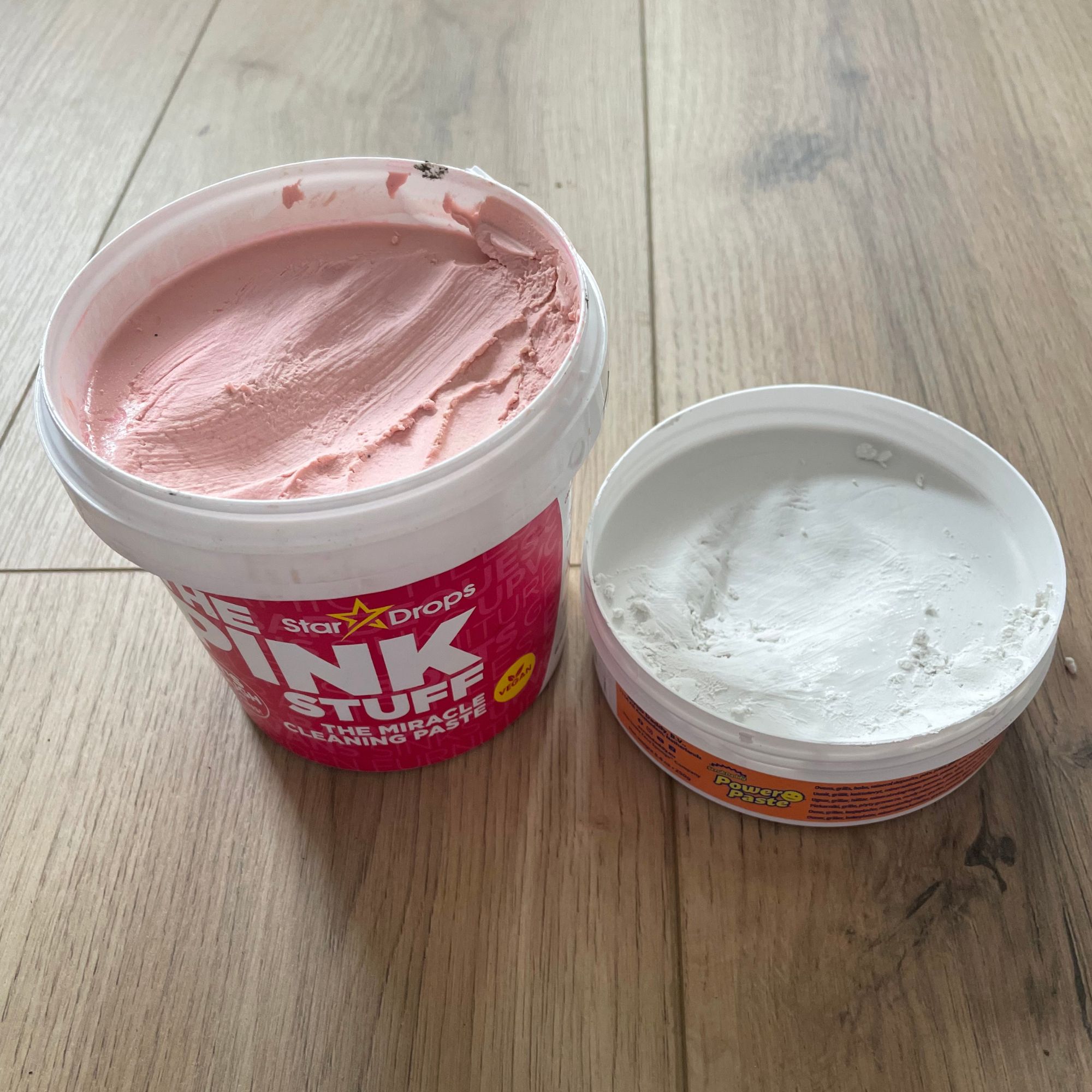 Tub of the Pink Stuff next to a tub of the Scrub Daddy Power Paste
