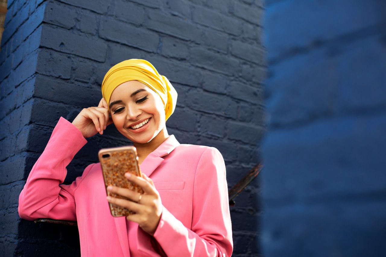 Young Muslim woman using phone